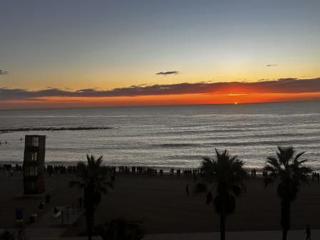 La moda japonesa de ver nacer el sol en la playa de la Barceloneta.