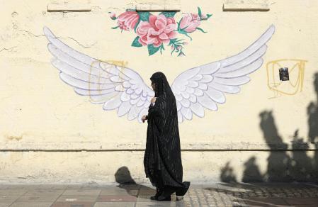 Tehran (Iran(islamic Republic Of)), 07/10/2024.- A veiled Iranian woman walks past a mural in a street in Tehran, Iran, 07 October 2024. Tensions are growing between Iran and Israel following Iran's large-scale missile attack on Israel. Iran fired more than 180 ballistic missiles directed at Israel late on 01 October 2024, in 'retaliation for different assassinations' carried out by Israel and 'the crimes in Palestine and Lebanon', Islamic Revolutionary Guard Corps (IRGC) said. Israel's prime minister Benjamin Netanyahu said that Iran will pay for the 'big mistake'. (Líbano, Teherán) EFE/EPA/ABEDIN TAHERKENAREH