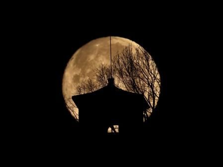 La luna llena con la iglesia de Sant Cristòfol.