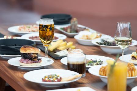 Una mesa con comida y bebida durante la presentación del Time Out Market, en el Centro Comercial Maremagnum, a 3 de julio de 2024, en Barcelona, Catalunya (España). Time Out ha destinado 13 millones de euros a la apertura de su primer espacio Time Out Market en España. Con sus 14 locales, Time Out Market Barcelona muestra la escena gastronómica de la ciudad condal y hace accesibles a los chefs más premiados. Dispone de un restaurante de servicio completo, cuatro bares, un espacio para eventos y un estudio de grabación.