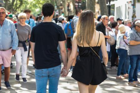 Una pareja de jóvenes en actitud cariñosa por el centro de Barcelona
