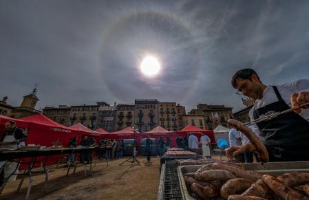 Cocinando en la Plaça del Mercat de Vic con el halo solar de fondo.