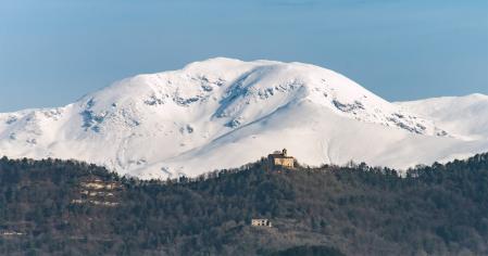El Puigmal a lo lejos, nevado, detrás de la lejana ermita de Santa Margarida de Vinyoles, visto desde Sant Bartomeu del Grau.