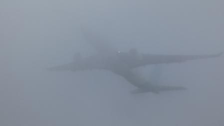 El A330 de LEVEL sobrevolando la playa de Gavà, atravesando los espesos bancos de niebla costera.