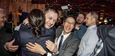Jens-Frederik Nielsen, del Demokraatit, abrazado por compañeros de partido en un café de Nuuk, en la madrugada del miércoles 12 de marzo (Mads Claus Rasmussen / Ap-LaPresse)