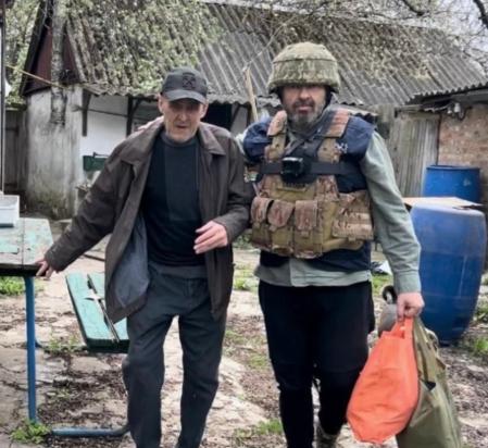 Andrés Torres ayudando a un hombre mayor en una zona de guerra&nbsp;&nbsp;