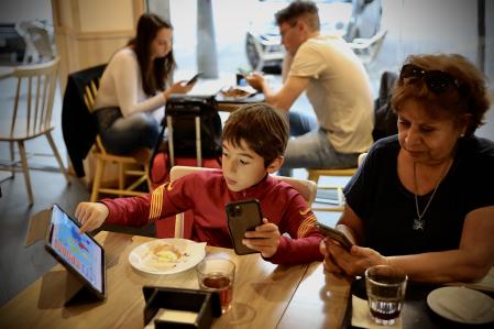 Un niño de 8 años merienda con su abuela entre el colegio y la extraescolar, en el Eixample ,Barcelona
