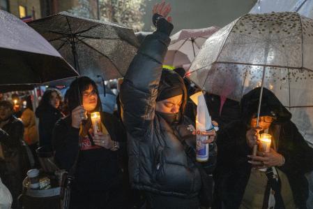 Un grupo de personas participan en una vigilia este viernes, en la plaza Quisqueya en Nueva York (Estados Unidos).