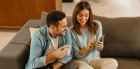 Una pareja mira el móvil para consultar los mejores chollos del día en Amazon