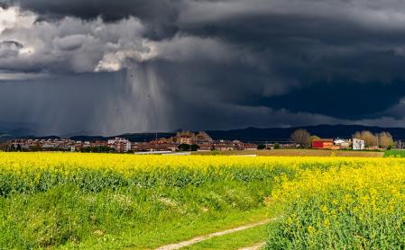 Cortinas de lluvia iluminadas por el sol en Vic.