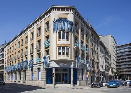 Fachada principal de la oficina de BBVA en Girona decorada con la instalación floral ‘Arrelats’ durante la edición de Temps de Flors 2021