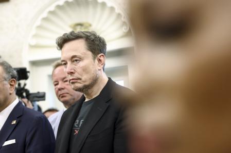 Elon Musk escuchando una declaración de Donald Trump