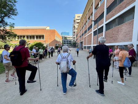 Antes de iniciar la tradicional caminata, la Dra. Vehí junto a su grupo de marcha nórdica, realiza estiramientos en el Jardí dels Drets Humans, (Barcelona), una rutina clave que prepara los músculos, previene lesiones, mejora la movilidad, en un espacio donde el ejercicio, la salud y la convivencia se dan la mano.