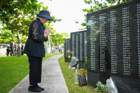 Una mujer reza frente al memorial por los fallecidos en la batalla de Okinawa