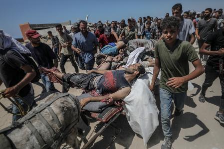 Los cuerpos de palestinos asesinados a tiros en un punto de distribución de alimentos cerca de Zikim son transportados en una carreta tirada por burros en el norte de Gaza.<br>