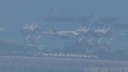 Imagen captada desde Begues, del A380 de Emirates en paralelo al barco, sobrevolando el puerto de Barcelona en aproximación al aeropuerto de El Prat.