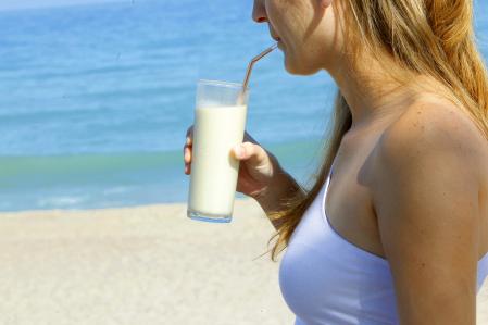 Una mujer bebe horchata en la playa