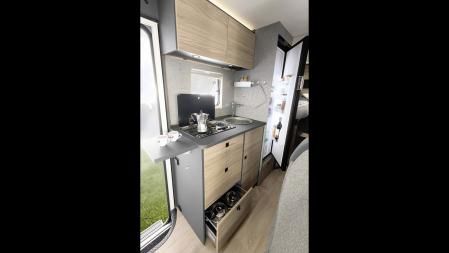 La cocina tiene dos fogones, un pequeño fregadero y una nevera bastante grande 