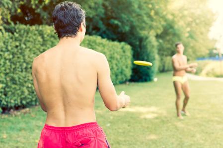 Unos amigos juegan a frisbee en una piscina