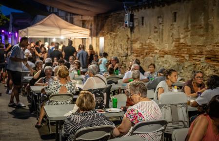 Algunos de los reunidos en la butifarrada popular, con la carpa de bar en el fondo