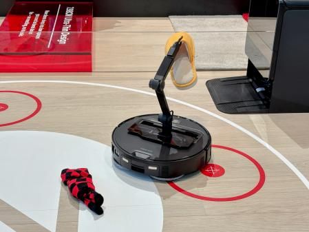 Un robot de Roborock recogiendo zapatilas y calcetines.