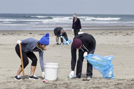 Un grupo de voluntarios colaboran en la limpieza de una playa de California