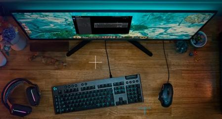 Teclado de logitech en un escritorio junto a un monitor y un mouse.