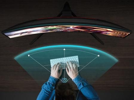 Una persona tecleando ante el monitor curvo