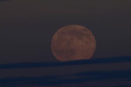 Superluna del Castor entre nubes vista desde el Far de Sant Sebastià.