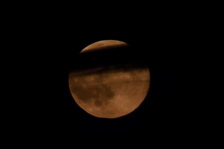 Superluna del Castor entre nubes vista desde el Far de Sant Sebastià.