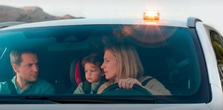Una familia espera la llegada de la asistencia tras señalizar la avería de su coche 