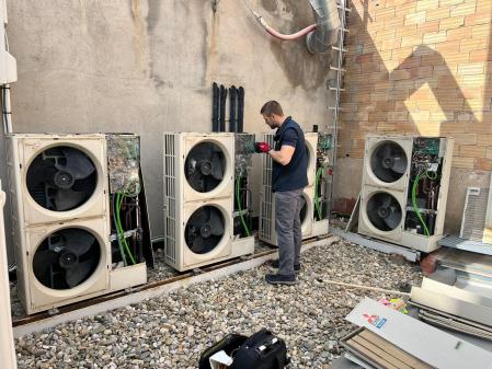 Un empleado de Domustec Climatización revisando 4 unidades exteriores VRV