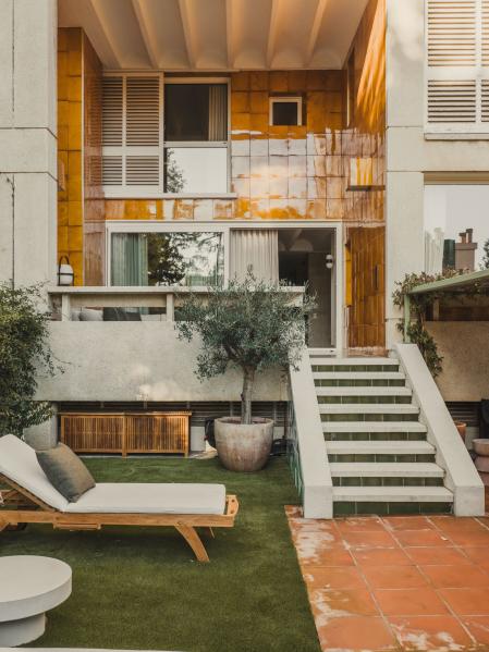 La terraza, a dos niveles, con cerámica de La Bisbal ocre y persianas de librillo