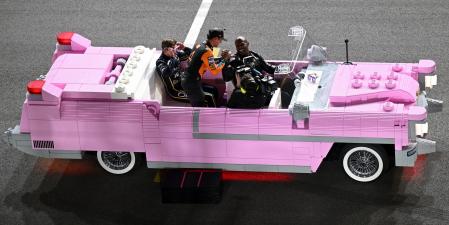 Un Cadillac rosa hecho de piezas de Lego rodando en circuito.