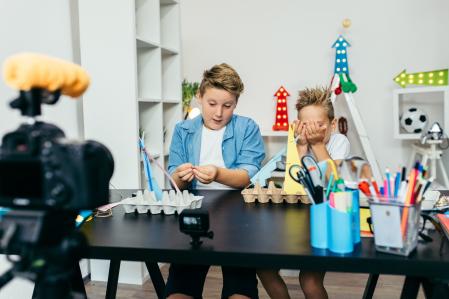 Niños realizan manualidades ante la cámara.