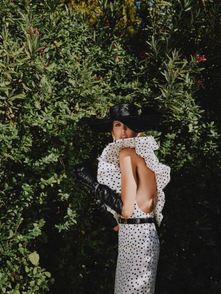 Vestido de seda con volante de Gucci, guantes de Varade y sombrero de Mimoki. Joyas Serpenti y B.zero1 de Bulgari