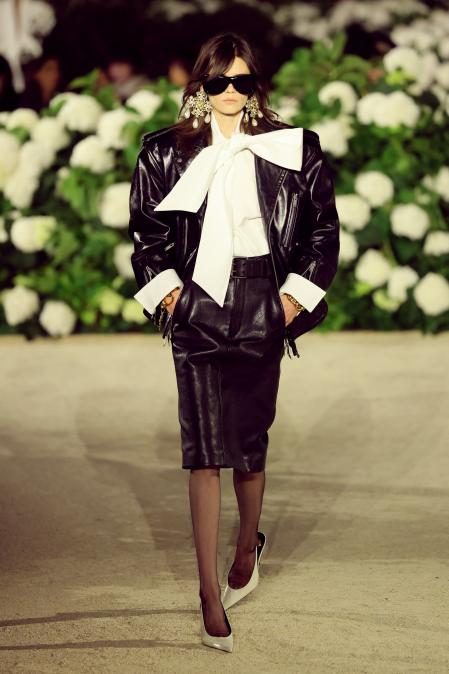 Una modelo con un look de Saint Laurent que destaca por una camisa blanca con una gran lazada