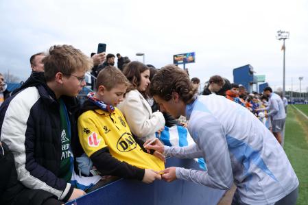 Carlos Romero firma un autógrafo a un aficionado del Espanyol en el entrenamiento de puertas abiertas.