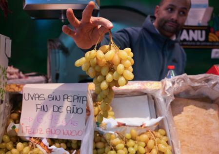 Expositor con uvas en una frutería de un mercado de abastos. A 30 de diciembre de 2024, en Sevilla (Andalucía, España). Las familias ultiman sus compras para despedir el año en la cena de Nochevieja y la celebración de la entrada del año con las tradicionales doce uvas.