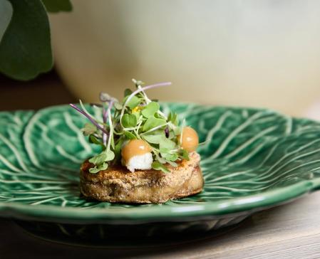 El llamado “Bocado Chiripa”: un crujiente de oreja y careta de cerdo con anguila ahumada, praliné de ajo y un gel de lima que aligera el conjunto.