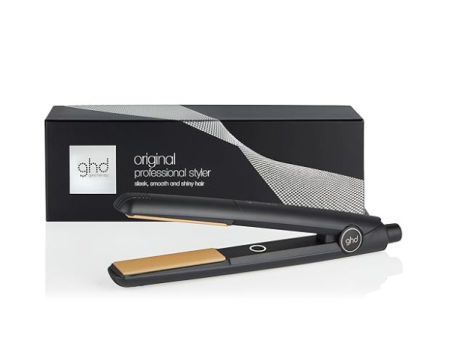 Plancha de pelo ghd Original Styler negra con placas doradas y su caja original sobre fondo blanco