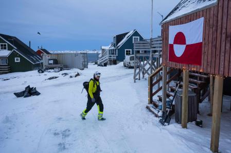 Un trabajador pasando junto a una casa con la bandera de Groenlandia, en Nuuk, el 22 de enero del 2026 