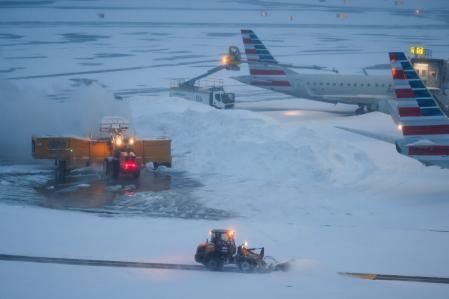 Una excavadora trabaja cerca de un avión de American Airlines en el Aeropuerto LaGuardia (LGA) en Queens, Nueva York, el domingo 