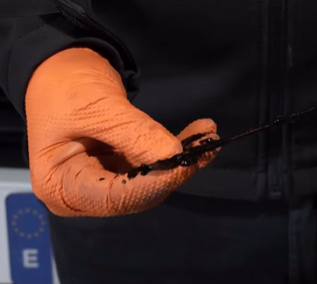 Juan José Ebenezer enseña un aceite oscuro, asegurando que está en buen estado