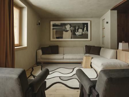 El salón está orientado a oeste para disfrutar de las puestas de sol. Cortinas de cuero y alfombra diseño de Faye Toogood