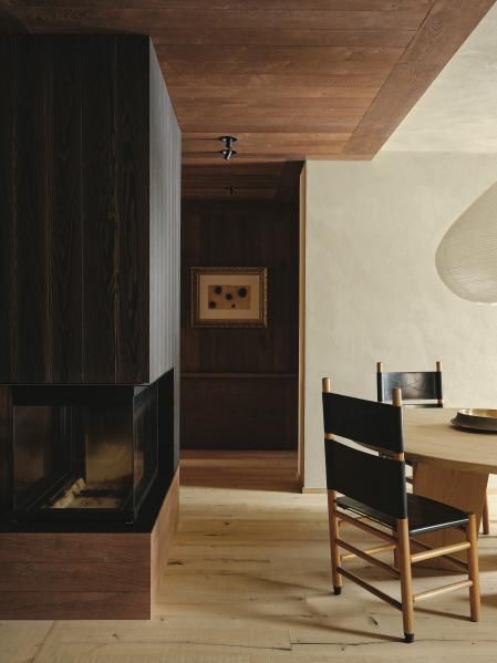 La chimenea está revestida con tablones de madera negra cepillados