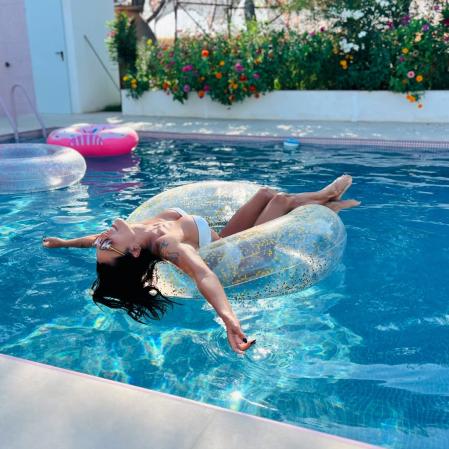 La piscina está revestida con azulejos en tonos rosáceos.