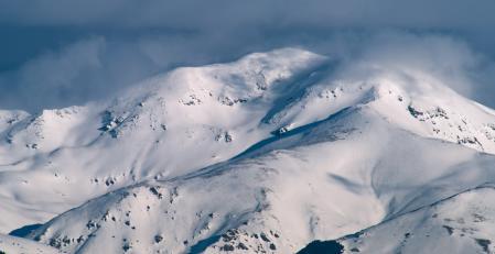 El monte Puigmal cargado de nieve, entre nieblas y nubes.