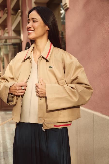 Xuan Lan con un vestido azul satinado y jersey de Maje a juego con una chaqueta beige de Lacoste.&nbsp;