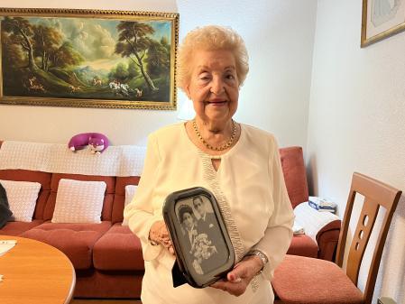 Carmen posa orgullosa en su salón sujetando una foto del día de su boda. Vestía de negro